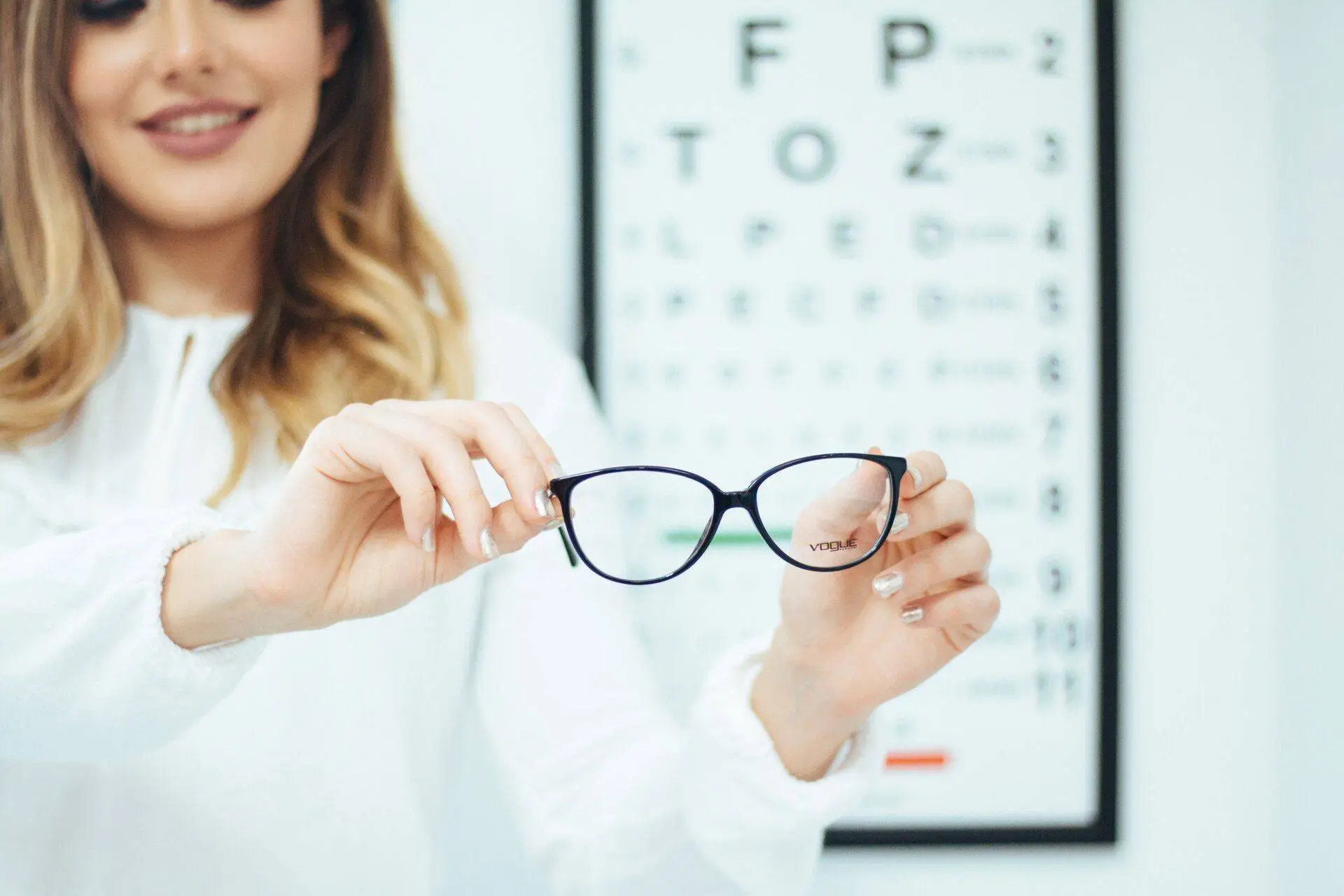 woman_holding_glasses_eye_exam
